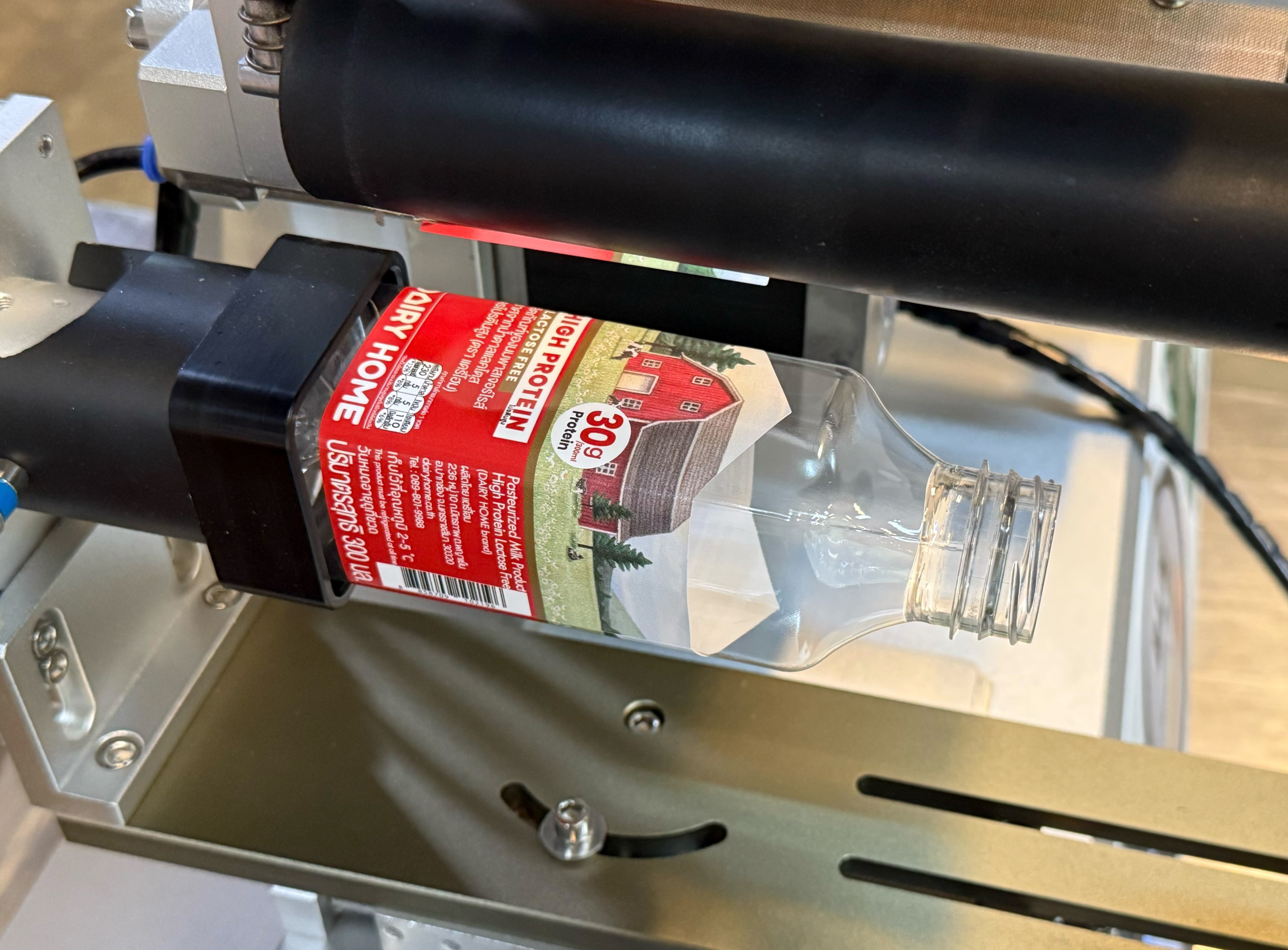 Film shrinking and sticker labelling machine